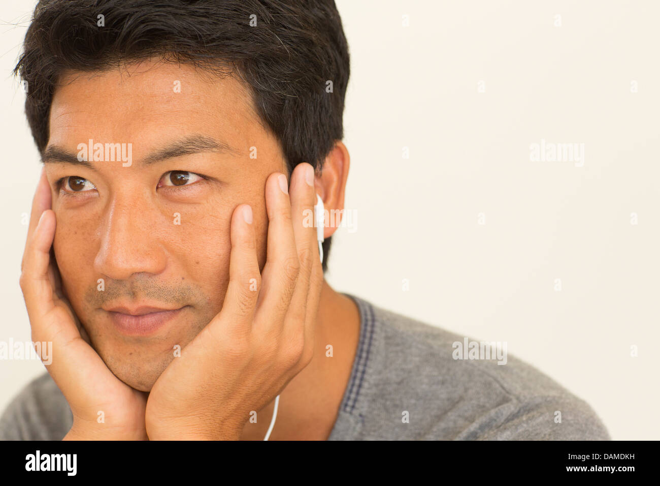 Uomo appoggiato mento in mani Foto Stock