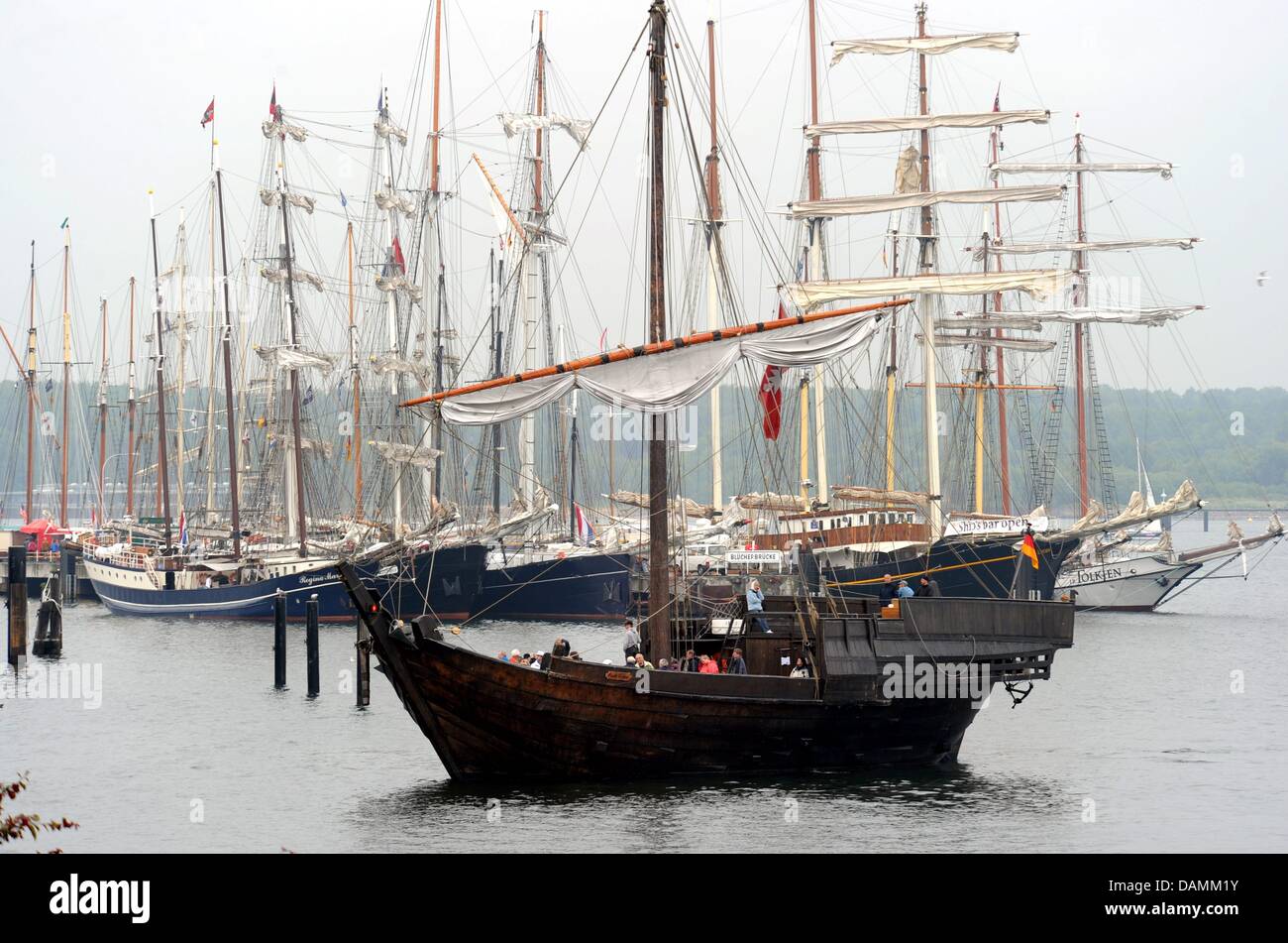 La riproduzione di un dente anseatica è raffigurato nella parte anteriore della barca a vela tradizionali navi ormeggiate nel fiordo di Kiel, Germania, 21 giugno 2011. A quanto pare a causa di condizioni atmosferiche variabili i visitatori attesi' numero di tre milioni di euro non verrà raggiunto. Foto: CARSTEN REHDER Foto Stock