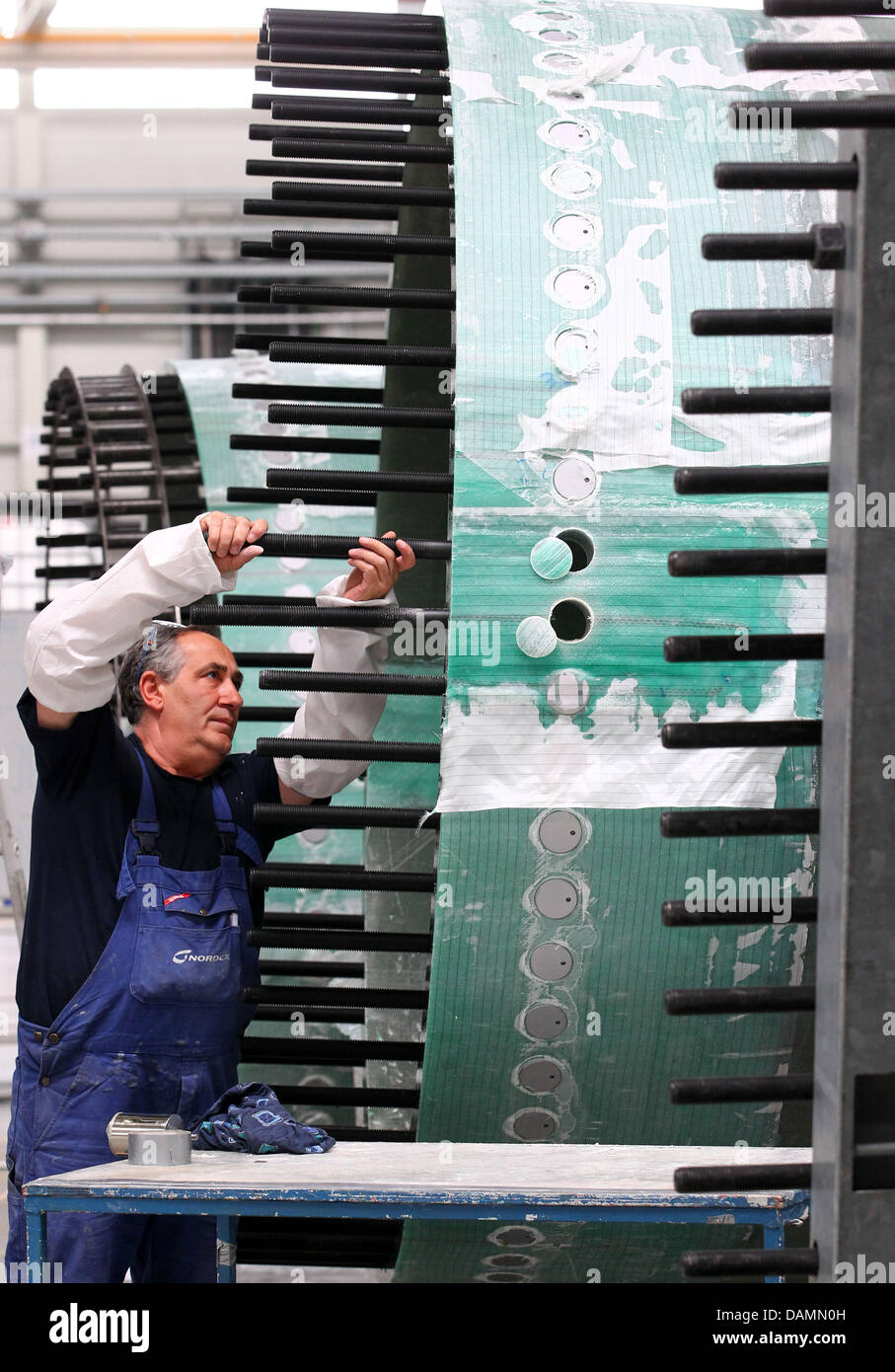 Il dipendente lavora su una pala di rotore di turbine eoliche a un assembly hall del produttore della turbina eolica Nordex in Rostock, Germania, 23 giugno 2011. Nordex modernizzato la sua produzione europea sede a Rostok. La produzione di flusso deve aumentare il rendimento e la qualità del motore case, mozzi e treni di guida. Foto: Jens Buettner Foto Stock