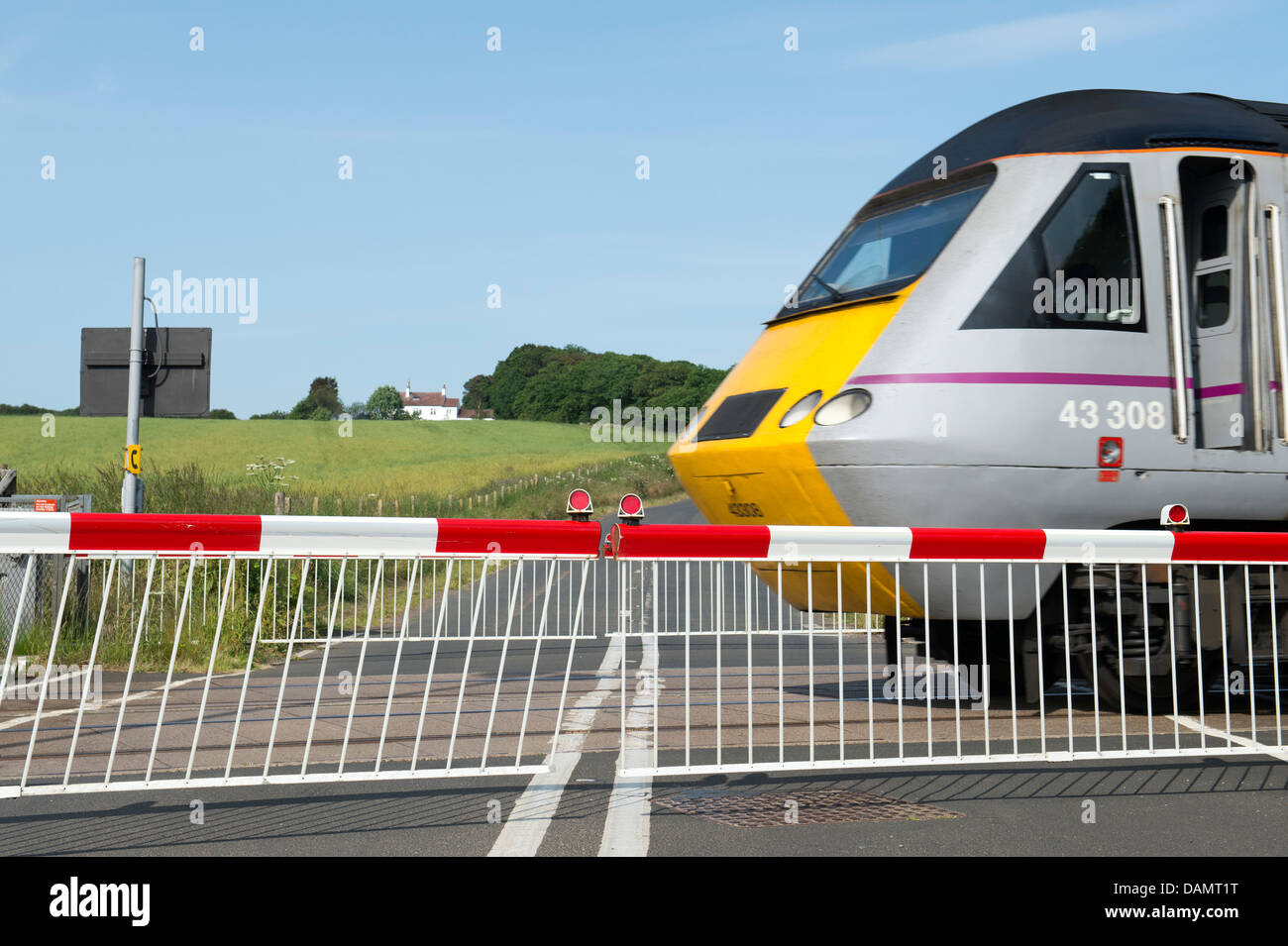 Passaggio a livello e il treno. Northumberland, Inghilterra Foto Stock