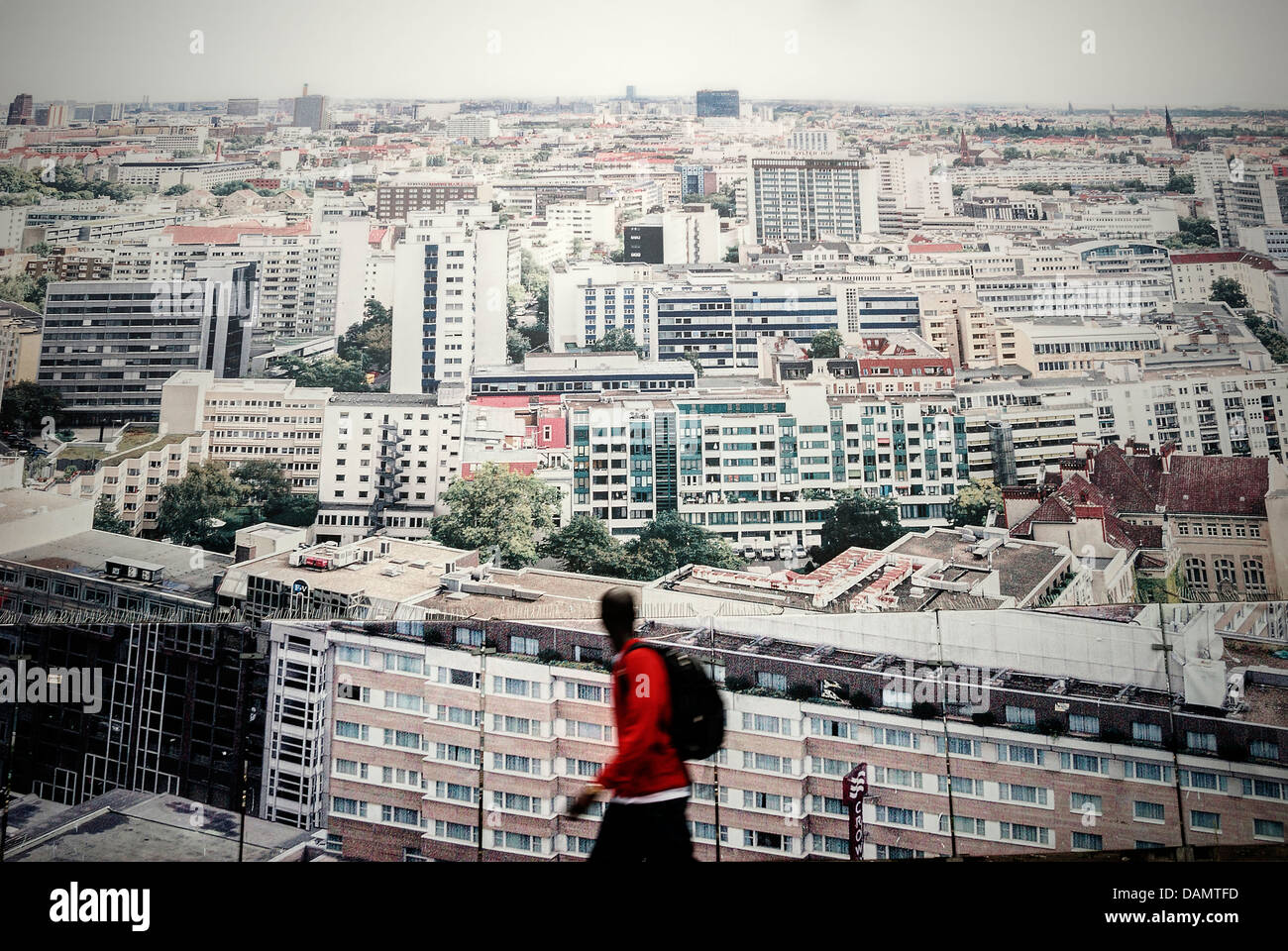 Germania Berlino. Uomo nero camminare vicino a una grande città tabellone a parete Foto Stock