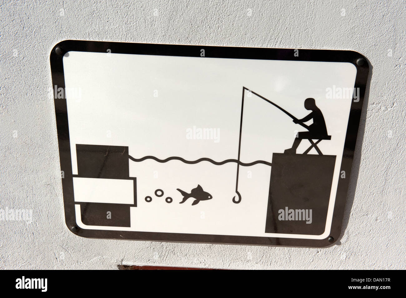 Uomo di Segno la pesca di mare Pesce asta a gancio la linea Foto Stock