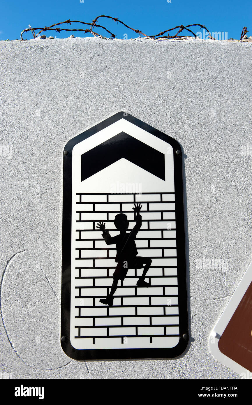 Segno uomo salire alto muro di mattoni e freccia in alto Foto Stock