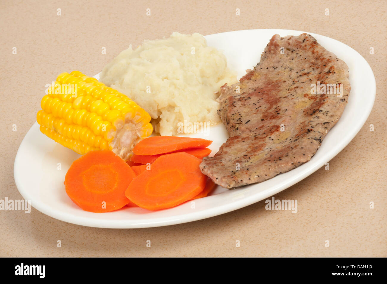 Una deliziosa bistecca per cena con purè di patate, mais e carote Foto Stock