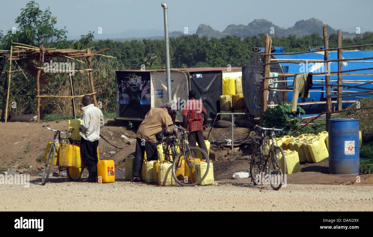 Water carrier Robert Malikeye (M) è illustrato dopo che egli ha riempito i barattoli con acqua potabile e legato alla sua moto a Juba nel sud Sudan, 2 aprile 2011. Il 30-anno-vecchio dall Uganda non ha preoccupazioni per il futuro per ora. Egli acquista un centinaia di litri di acqua in 10 litri di taniche per quattro libbre ciascuno. Allora egli li trasporta tediously attraverso il brillare strade sulla sua moto. Foto: Foto Stock