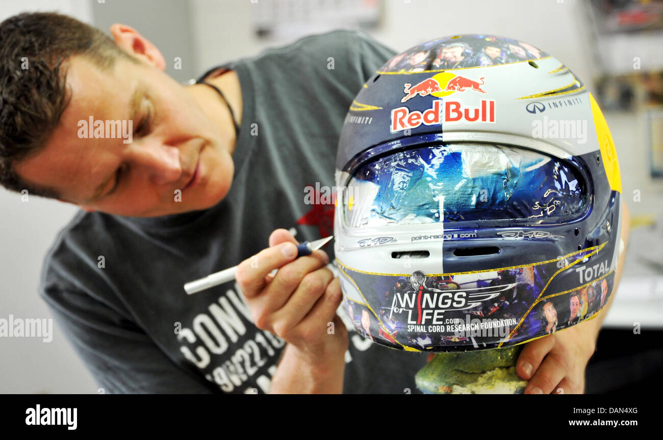 JMD casco designer Jens Munser opere su tedesco di Formula One champion  Sebastian Vettel è di nuovo casco presso il suo negozio in Salzgitter AG,  Germania, 06 luglio 2011. Vettel indossa dodici