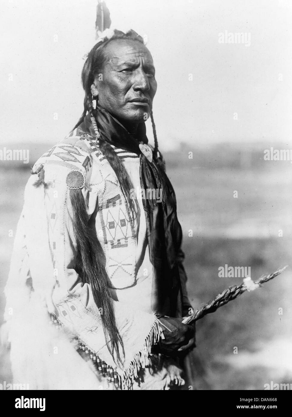 Disgregazione grande bocca e la molla con un decorato disgregazione patch sulla sua spalla destra. Fotografato nel 1910 da Edward S. Curtis Foto Stock