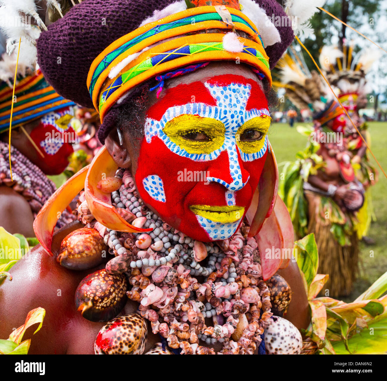 Donna tribale con il suo volto dipinto luminosamente e indossa una collana di conchiglie presso il festival di Goroka in Papua Nuova Guinea Foto Stock