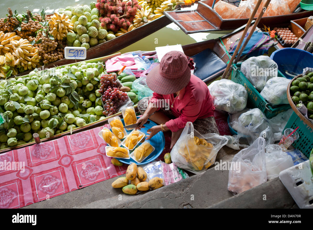 Thailandia, Bangkok, Donna vendita di frutta sul mercato galleggiante Foto Stock