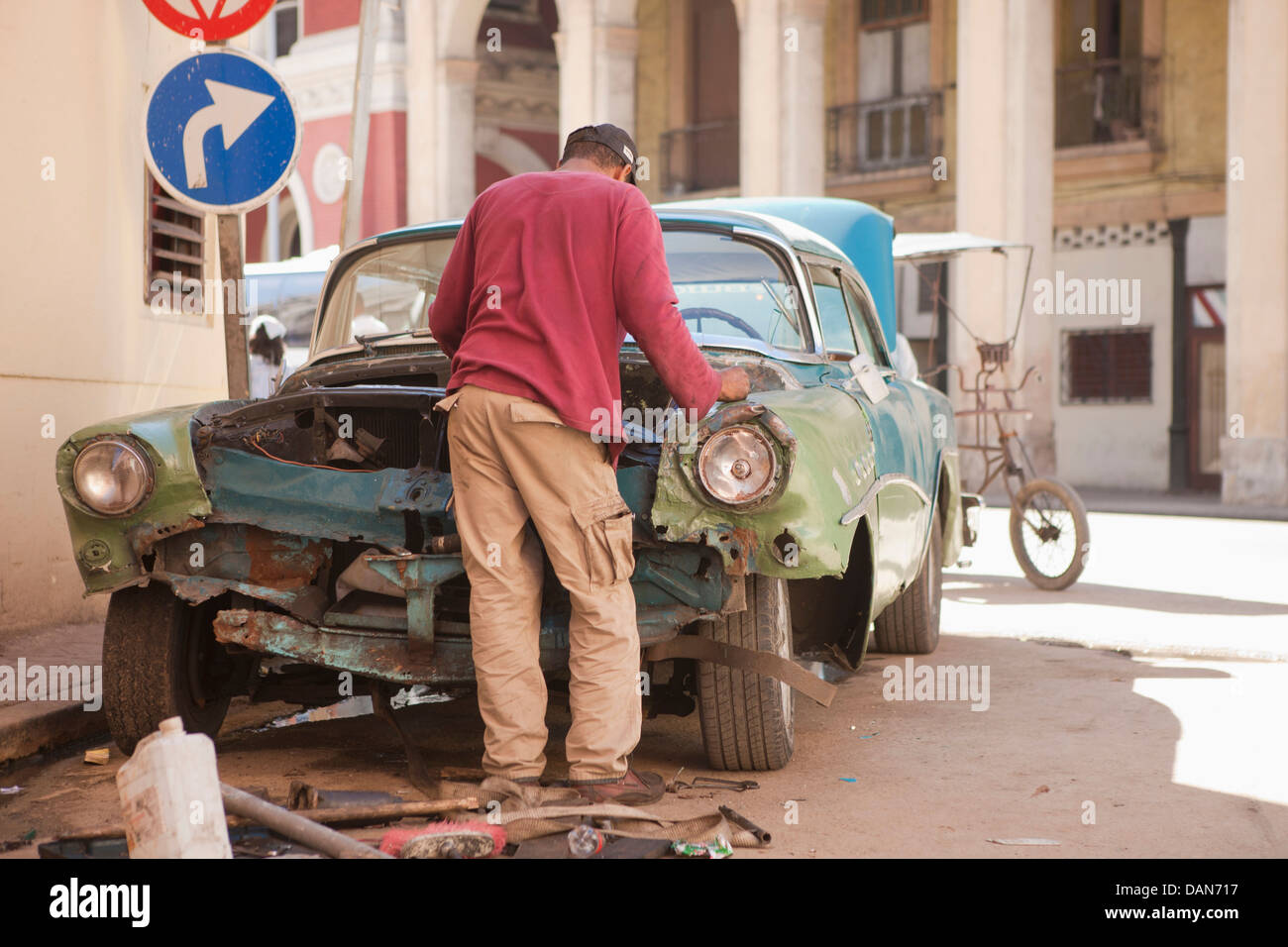 Cuba, La Habana, uomo cercando di riparare un vecchio automobile americana Foto Stock