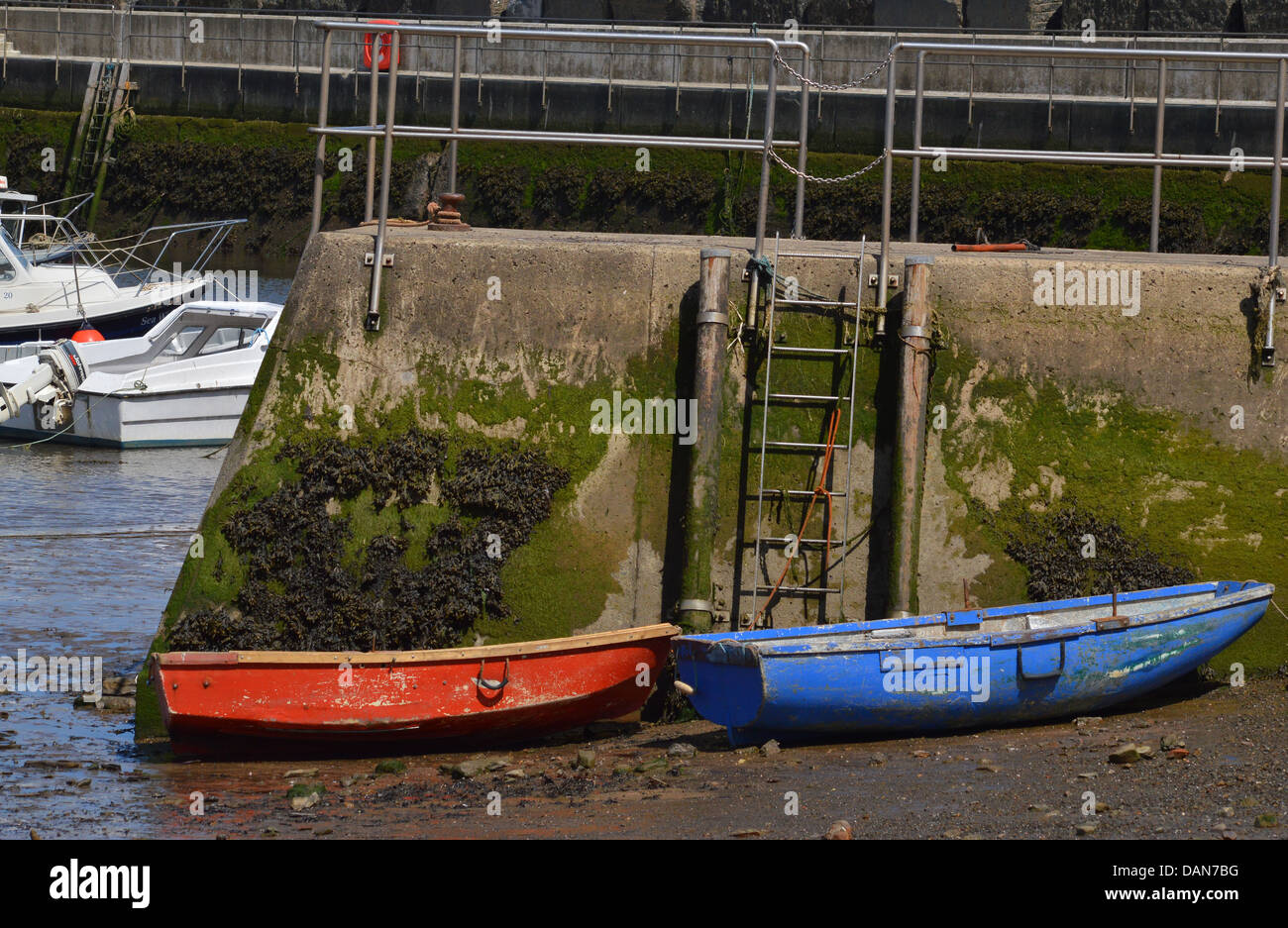 2 piccole imbarcazioni - uno rosso , uno blu - ormeggiata al Porto di Staithes beach , North Yorkshire Foto Stock