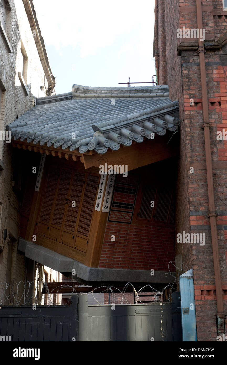 Casa Cinese incastrato tra alti edifici di arte pubblica Foto Stock