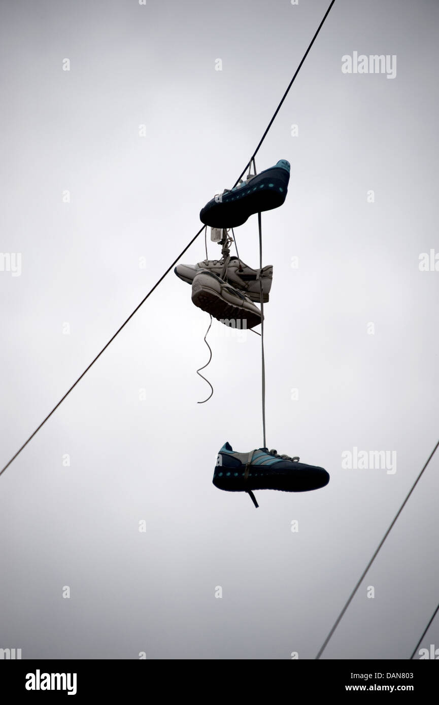 Trainer scarpe appesi da telefono cavo a filo Foto Stock