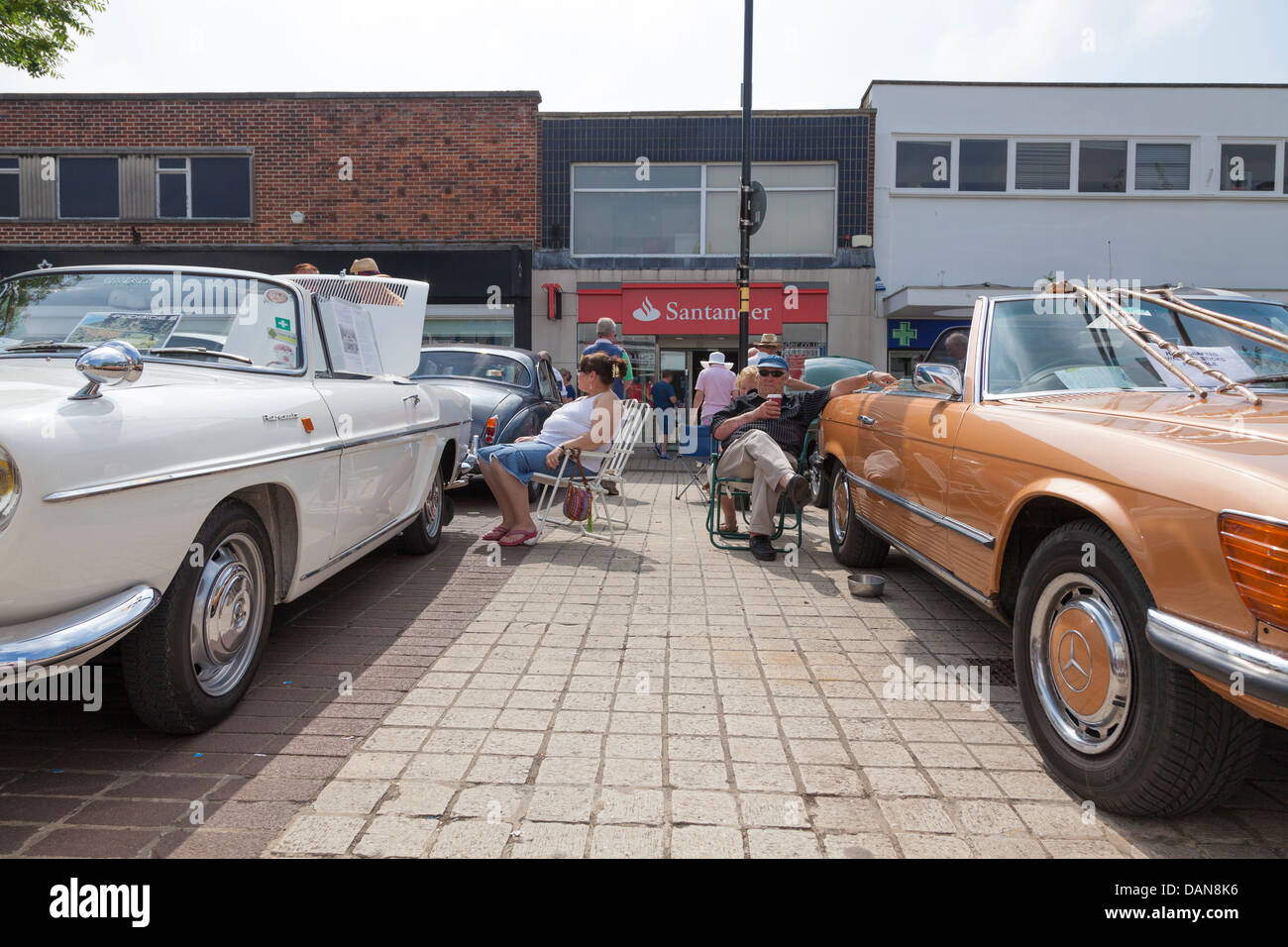 Proprietari seduti fianco a fianco con i loro automobili classiche a mostrare Foto Stock