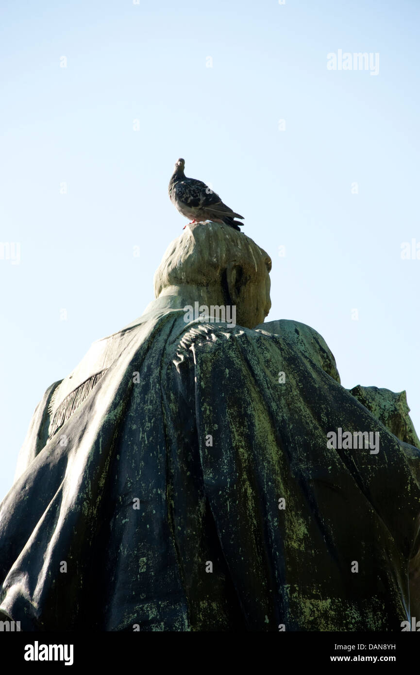 Pigeon Bird sulla testa della statua in bronzo poo muck Foto Stock