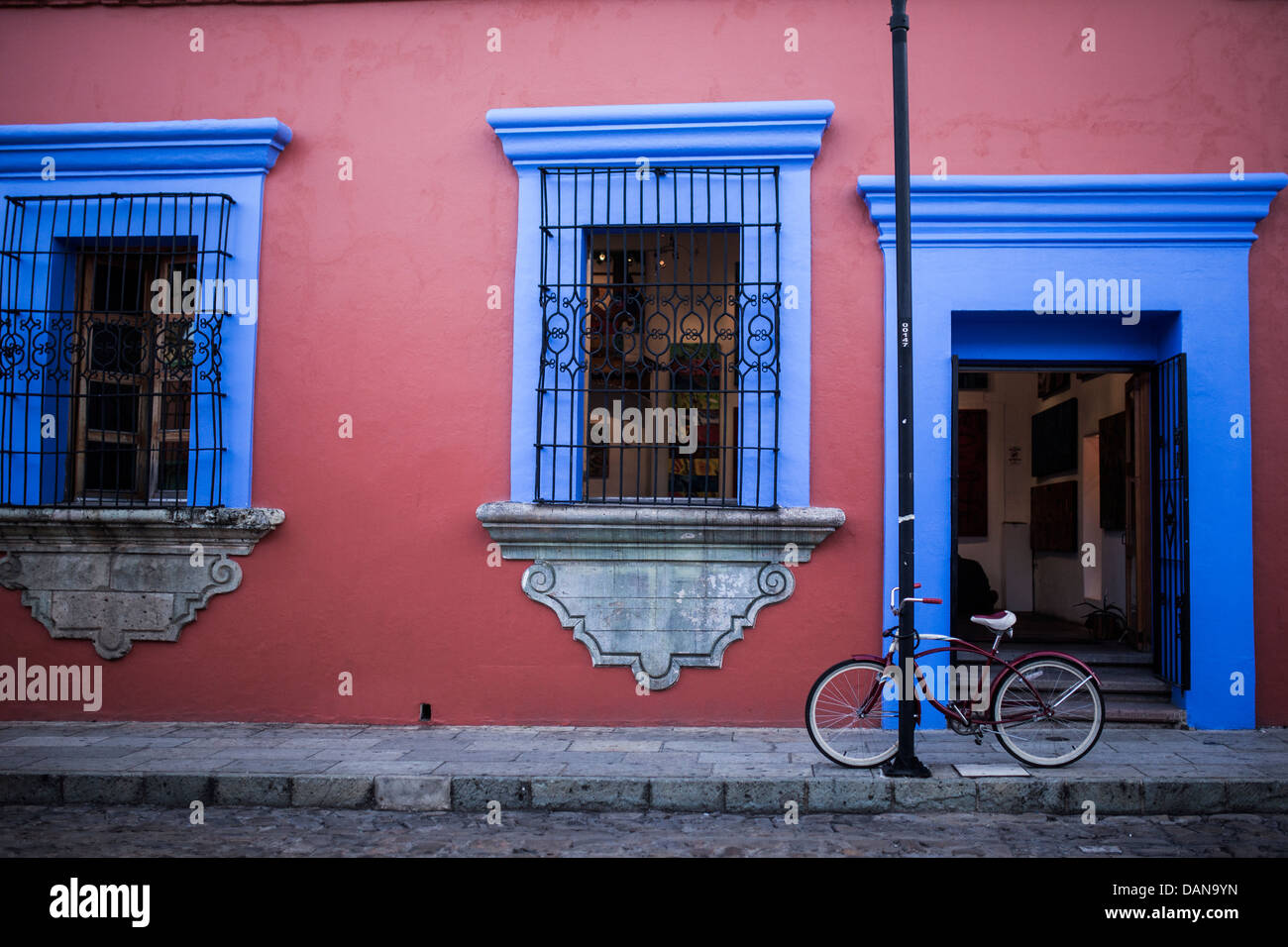 Un colorato Oaxacan vecchio edificio con un cruiser bike parcheggiato di fronte. Foto Stock