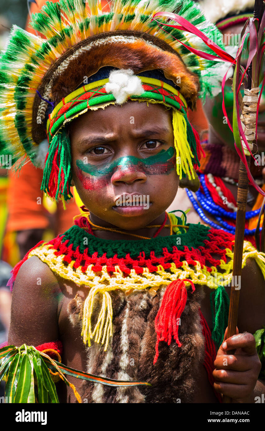 Ragazzo con il suo volto dipinto e indossa un copricapo tribali a Goroka show in Papua Nuova Guinea highlands. Foto Stock