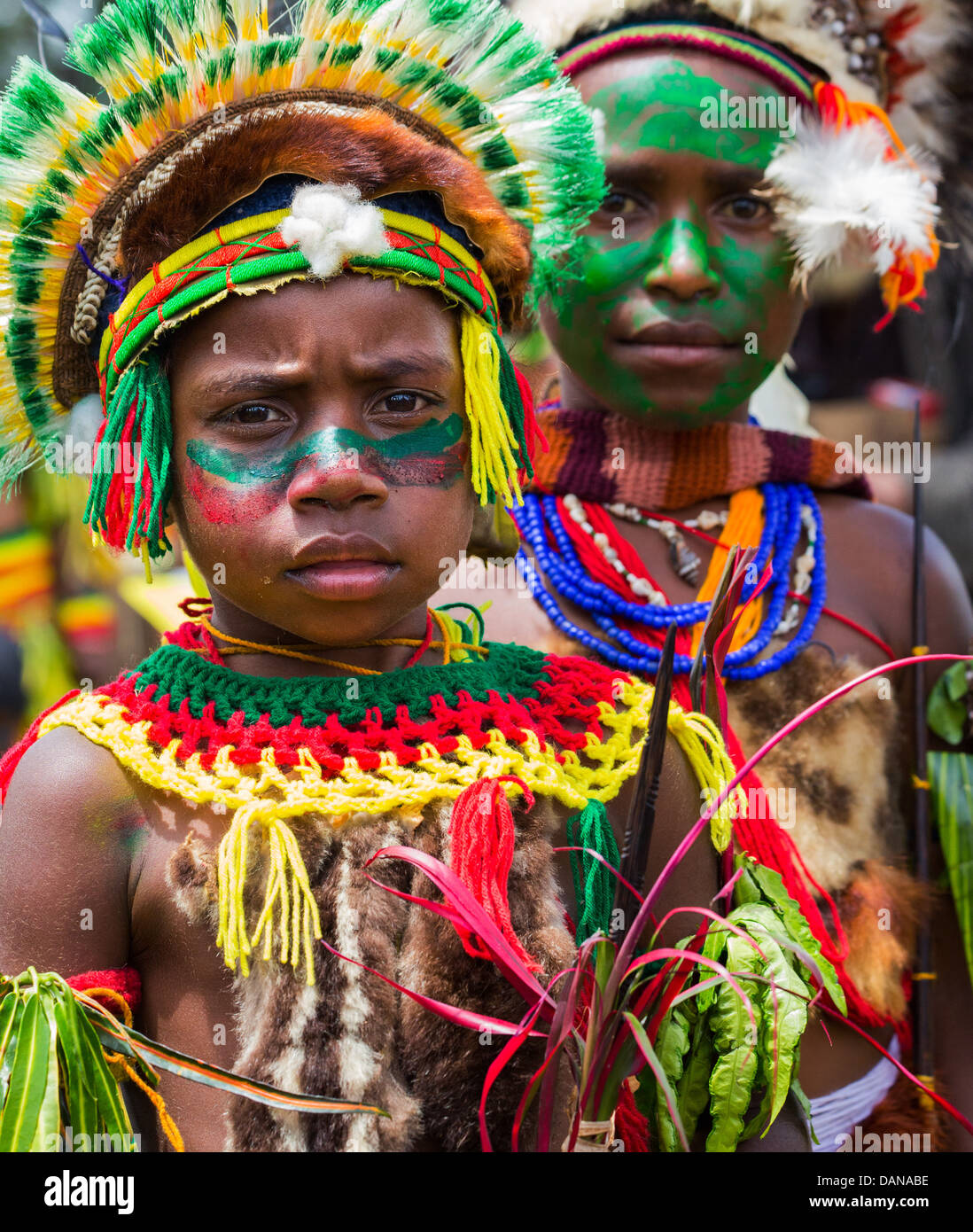 Ragazzo con il suo volto dipinto e indossa un copricapo tribali a Goroka show in Papua Nuova Guinea highlands Foto Stock