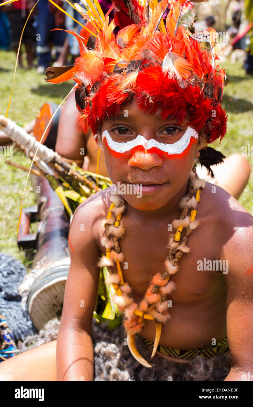 Ragazzo con il suo volto dipinto e indossa un copricapo tribali a Goroka show in Papua Nuova Guinea highlands. Foto Stock