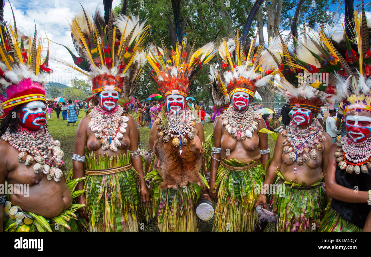 Donne che indossano grandi copricapi tribali e di erba gonne a Goroka show in Papua Nuova Guinea Foto Stock