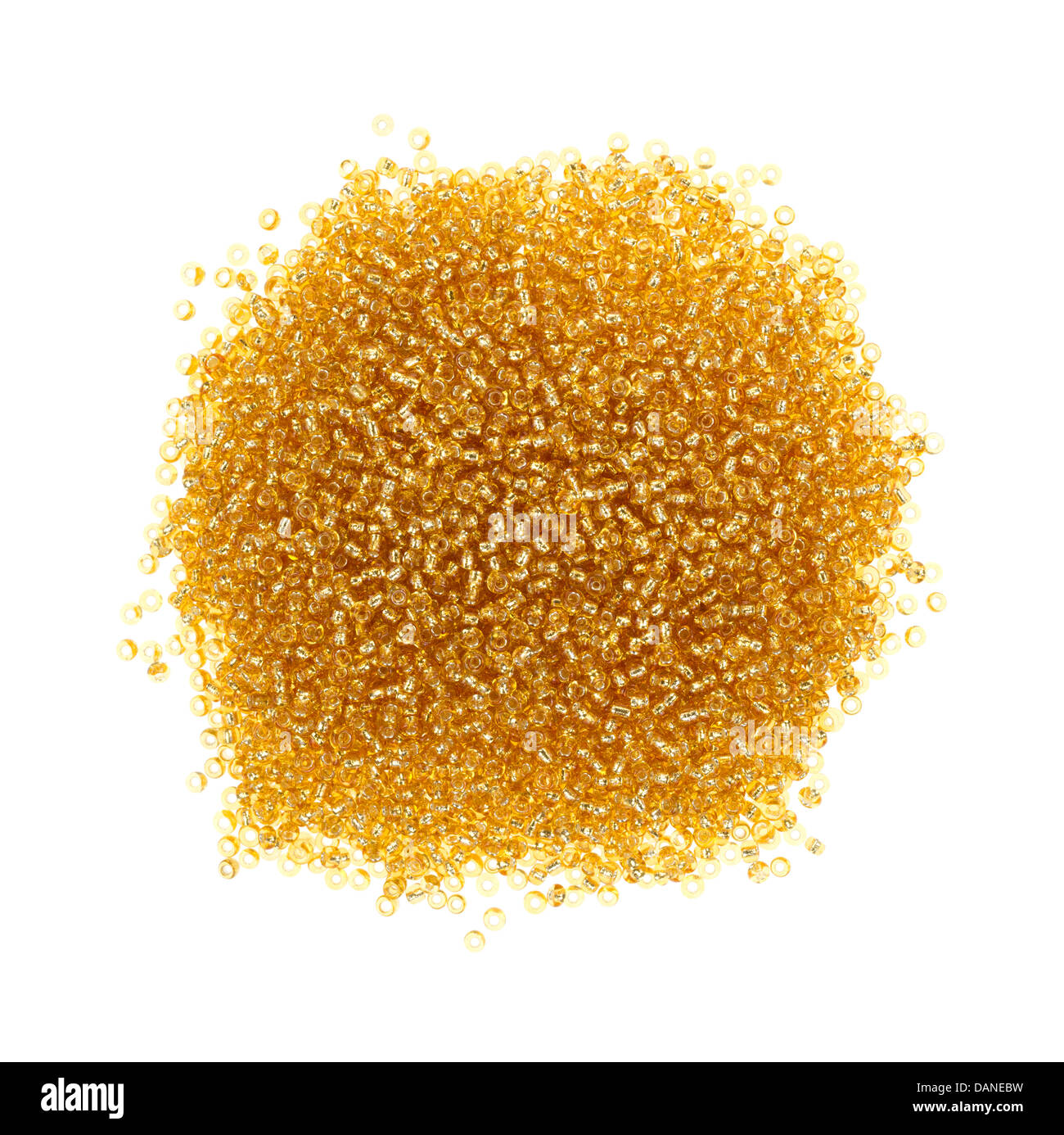 Vista superiore di una piccola pila di oro perle di vetro su uno sfondo bianco. Foto Stock