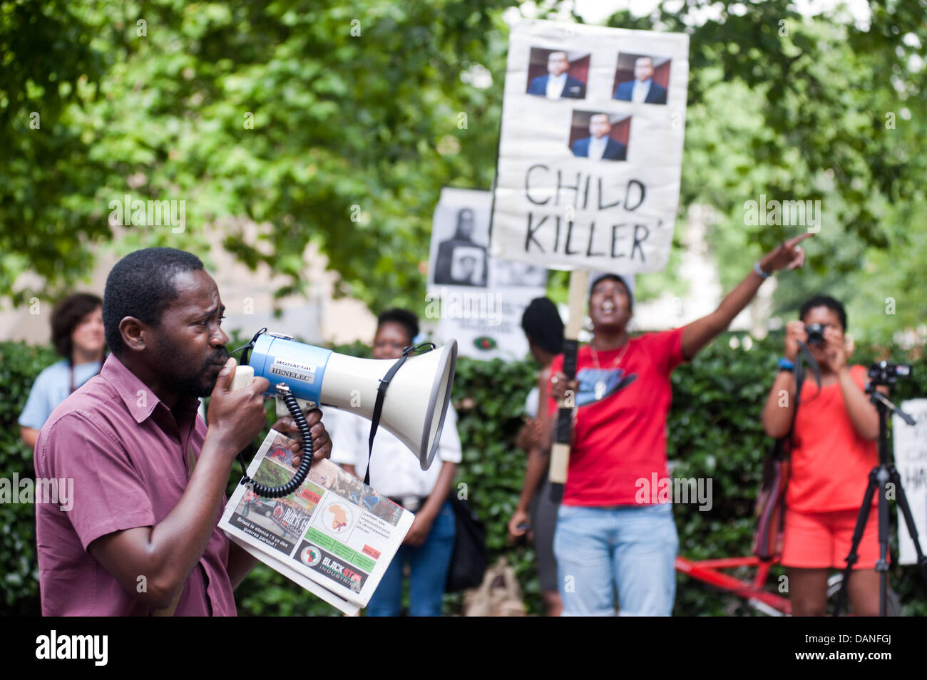 Londra, Regno Unito. 16 Luglio, 2013. un dimostratore parla sul megafono mentre una donna che tiene un cartello "lettura bambino killer' al di fuori dell'Ambasciata Americana per protestare contro la recente Trayvon Martins verdetto. Credito: Piero Cruciatti/Alamy Live News Foto Stock