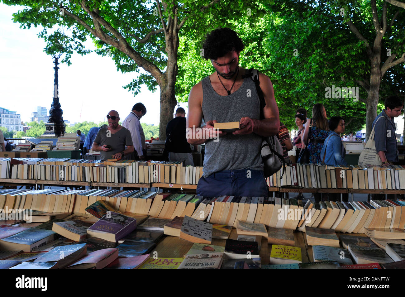 Un uomo la lettura di un libro, South Bank del mercato del libro, London, Regno Unito Foto Stock