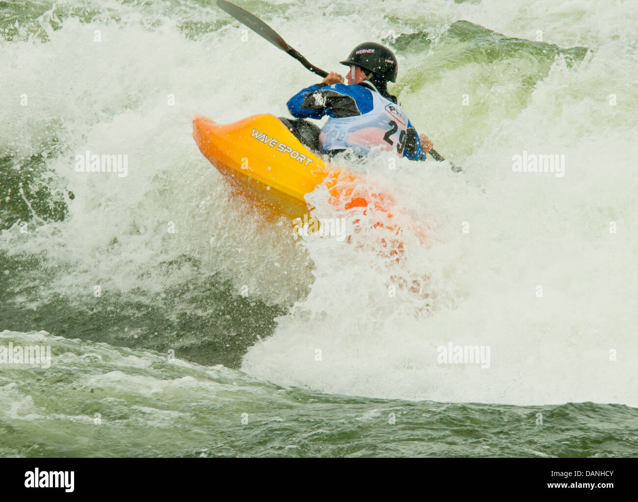 Kayaker femmina paddling attraverso potenti rapids mentre kayak freestyle sul fiume Payette, Cascata, Idaho Foto Stock