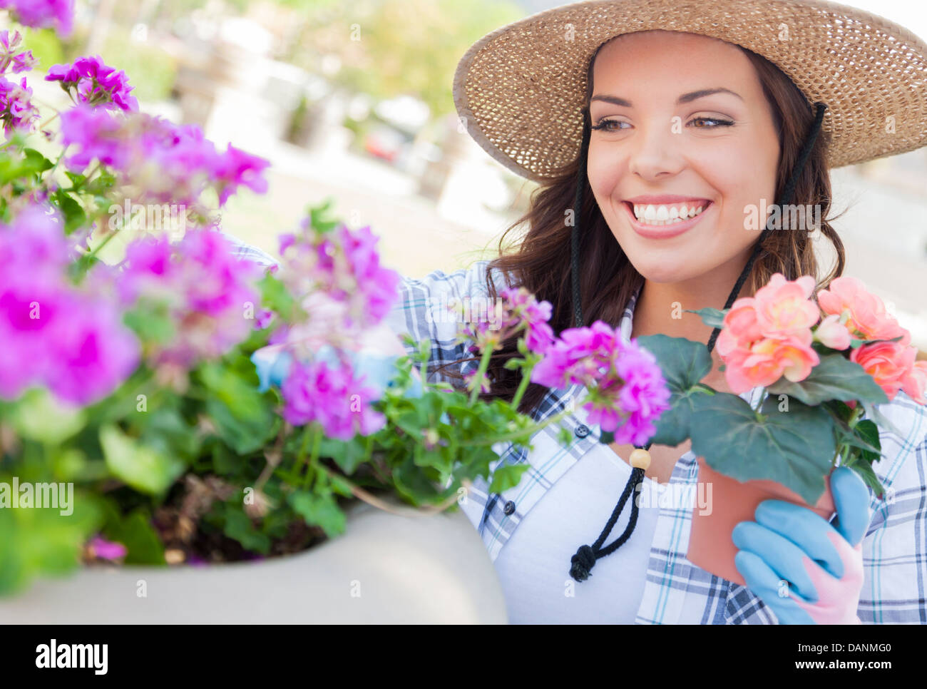 Attraente felice giovane donna adulta indossando Hat Giardinaggio all'esterno. Foto Stock