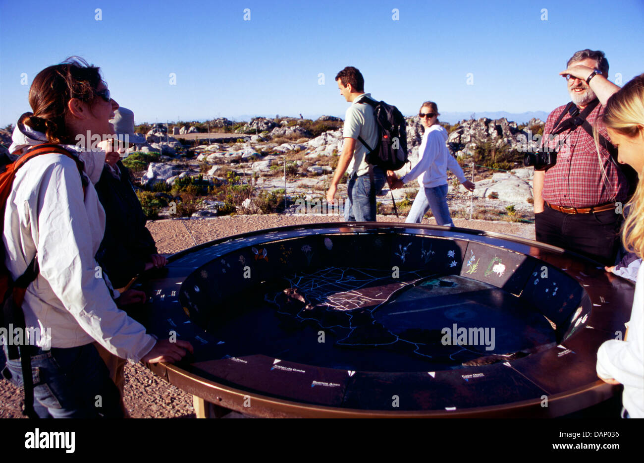 Turisti si riuniscono intorno a una mappa di Cape Peninsula fusa in bronzo sulla cima della montagna della tavola Foto Stock