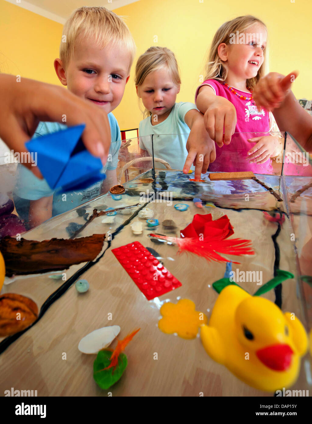 I bambini dell'AWO scuola materna "Kaethe Kollwitz' esperimento con la capacità di carico di acqua a Ilmenau, Germania, 14 luglio 2011. Ulteriori opportunità di apprendimento in scienze naturali o lingue straniere sono previsti in molti vivai. Foto: Michael Reichel Foto Stock