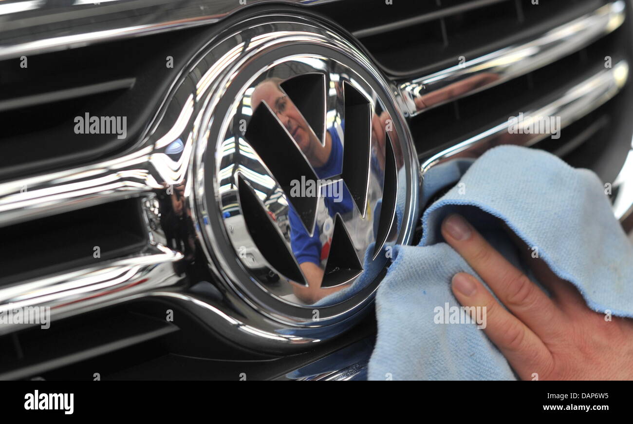 (Dpa) file - un file immagine datata 24 febbraio 2011 di un dipendente VW pulizia della parte anteriore di una macchina presso la sede centrale di Volkswagen a Wolfsburg, in Germania. Il 28 luglio 2011, costruttore di automobili Volkswagen presenterà i suoi semi-annuale di bilancio. Foto: Jochen Luebke Foto Stock