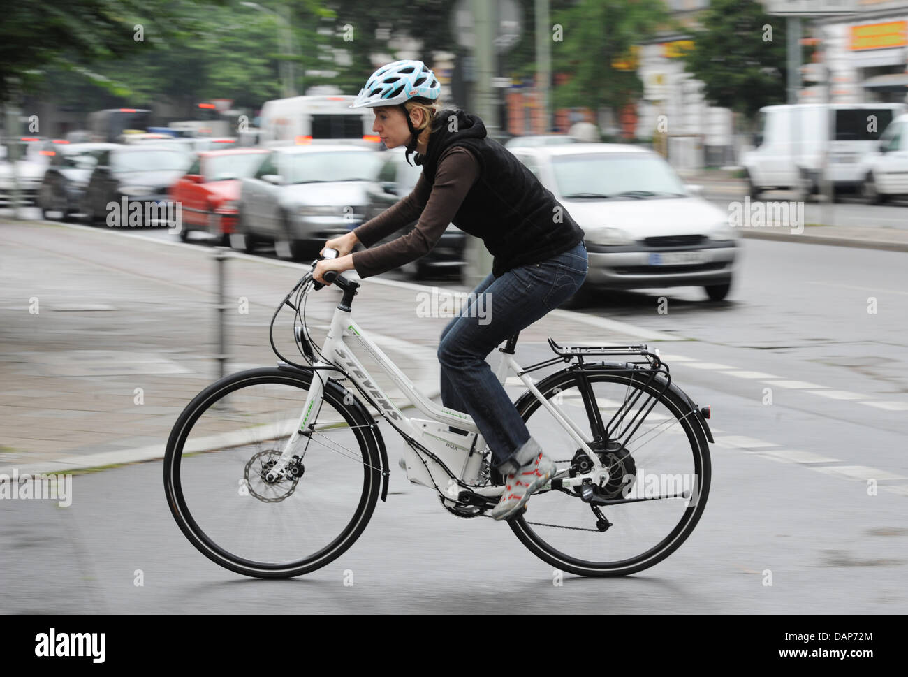 La donna corse in bicicletta elettrica a Berlino, Germania, 28 luglio 2011. I tedeschi sono ad esempio utilizzando biciclette elettriche sul modo di lavorare più spesso. Le biciclette con ulteriori motori elettrici sono molto alla moda, ma non tutti i modelli non sono all'avanguardia della tecnologia, secondo Stiftung Warentest e ADAC. Foto: Rainer Jensen Foto Stock