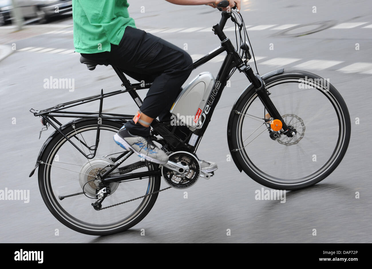 Un uomo corse in bicicletta elettrica a Berlino, Germania, 28 luglio 2011. I tedeschi sono ad esempio utilizzando biciclette elettriche sul modo di lavorare più spesso. Le biciclette con ulteriori motori elettrici sono molto alla moda, ma non tutti i modelli non sono all'avanguardia della tecnologia, secondo Stiftung Warentest e ADAC. Foto: Rainer Jensen Foto Stock