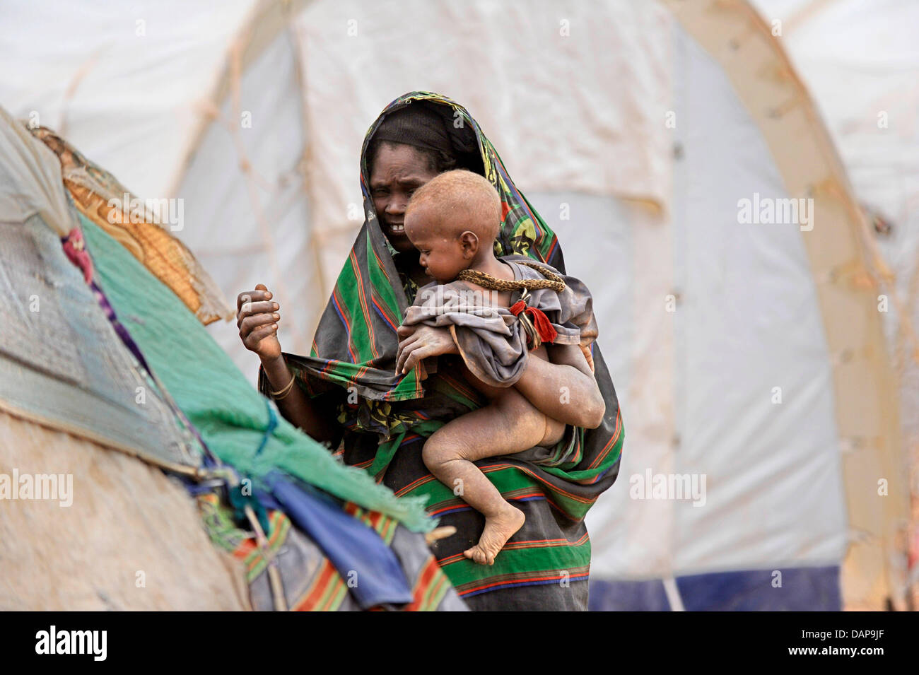 Una donna somala e suo figlio a piedi attraverso un campo profughi in un campo di rifugiati di Dadaab, Kenya 4 agosto 2011. Somalia e parti del Kenya è stata colpita da una delle peggiori le bozze e carestie in sei decenni, più di 350 000 profughi hanno trovato rifugio in mondi più grande campo di rifugiati. Foto: Boris Roessler Foto Stock