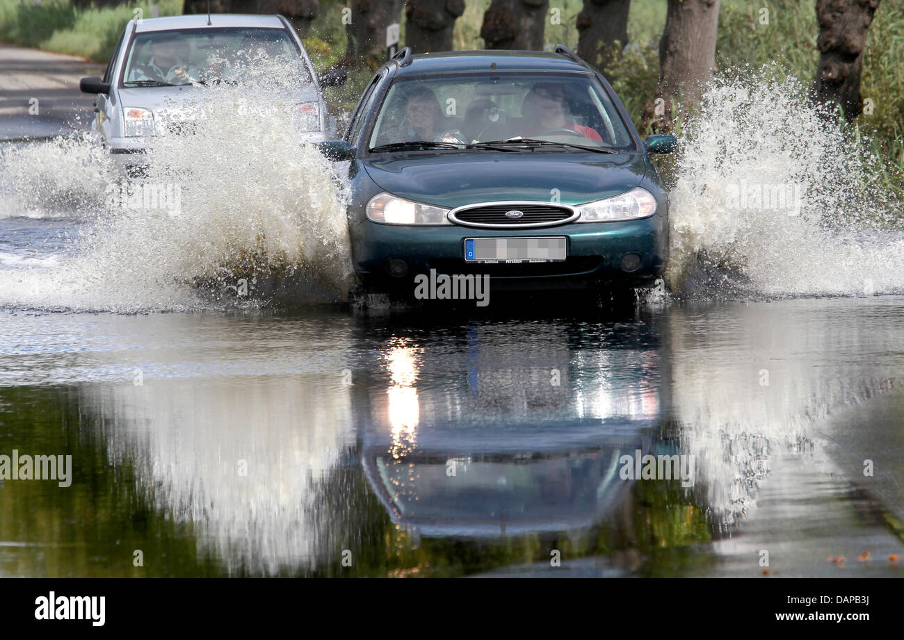 Un auto drive su un invaso Street nel quartiere di North Western Pomerania in Marlow, Germania, 8 agosto 2011. Dopo giorni di pioggia pesante, il livello di acqua è aumentato di 1,5 metri. Parti della città sono completamente allagato. La situazione nell'area inondabile lentamente comincia a diventare meno tesa. La maggior parte delle strade sono nuovamente chiara, secondo le autorità responsabili per la Pomerania occidentale Foto Stock