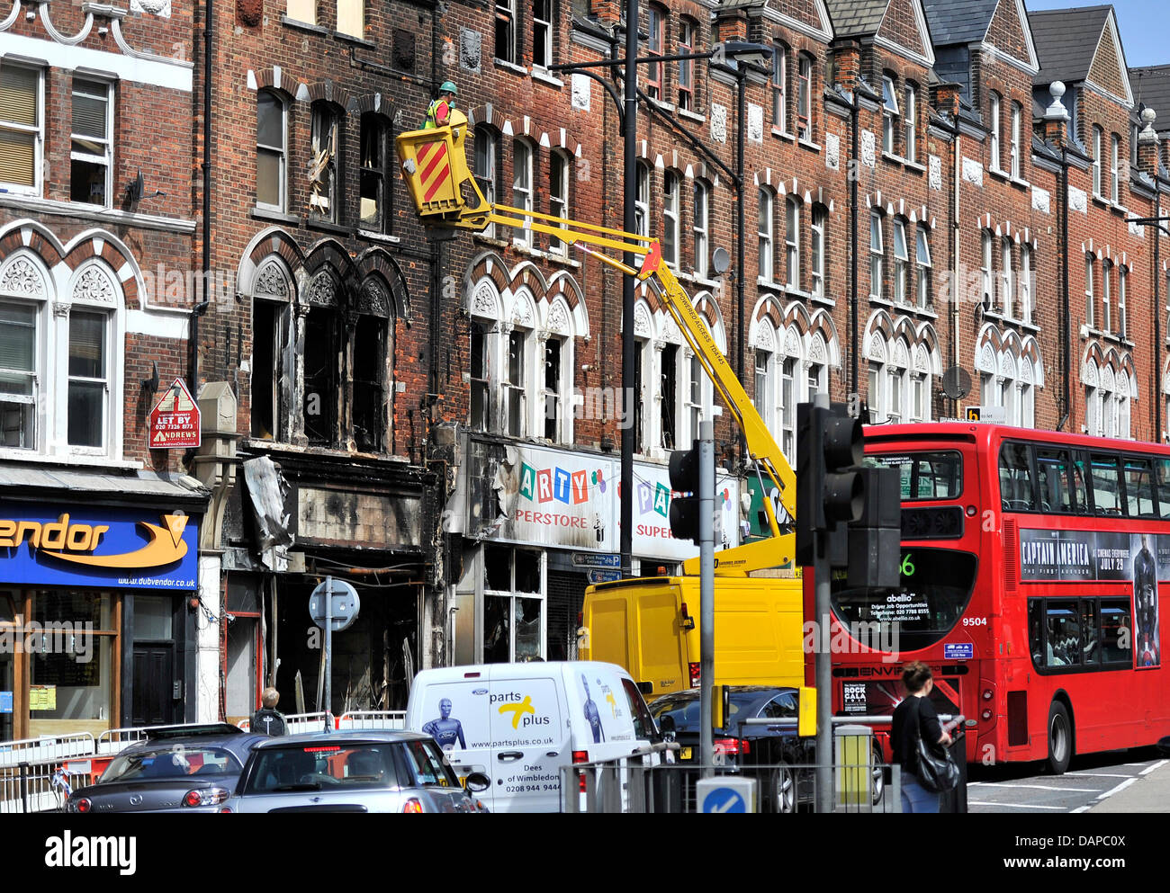 Lavoratori guardare una bruciò fuori casa dopo i tumulti a Clapham, Londra, Gran Bretagna, 10 agosto 2011. Scontri e saccheggi hanno continuato a Londra e in molte altre città britanniche per la quarta notte in una fila. Foto: MARIUS BECKER Foto Stock