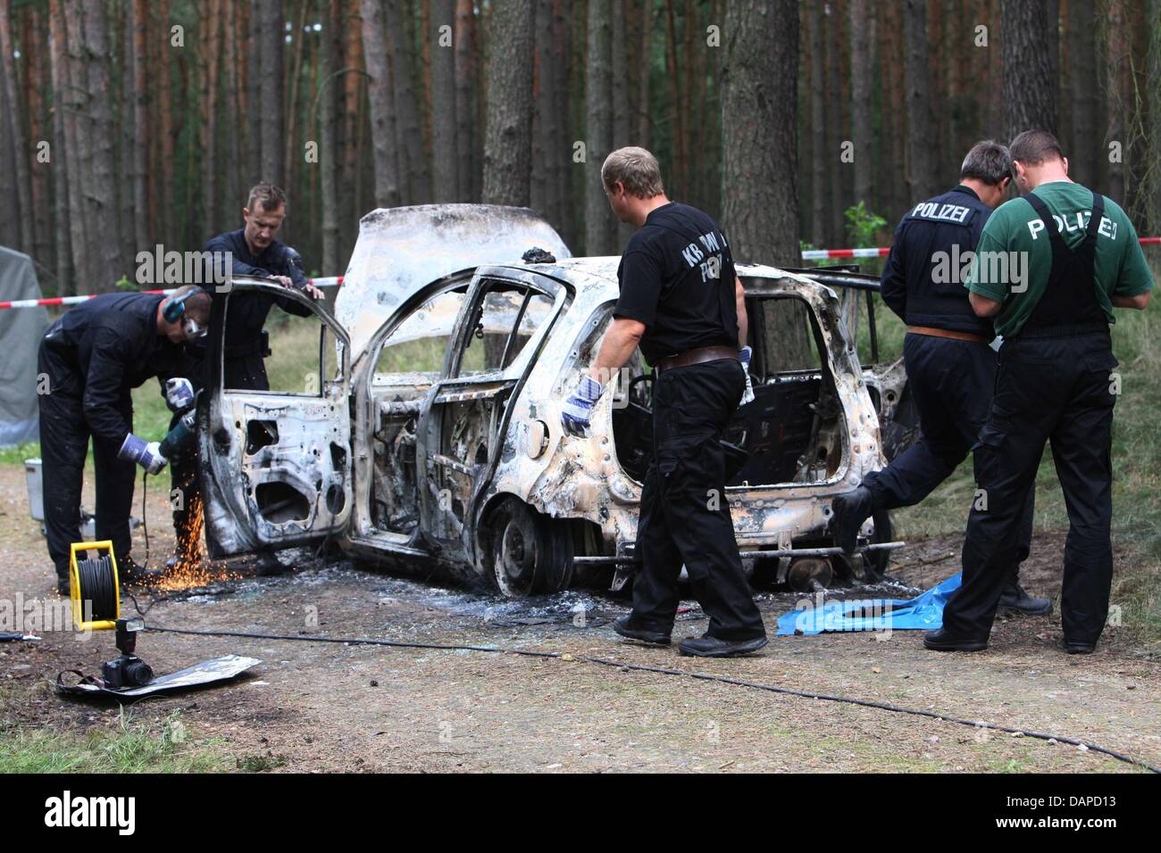 La polizia blocca un sito dove due bambini di cadaveri sono stati trovati in un pezzo bloccato di legno vicino Boernicke, Germania, 12 agosto 2011. Secondo la polizia, la bruciata auto è stata trovata la mattina. Foto: NESTOR BACHMANN Foto Stock