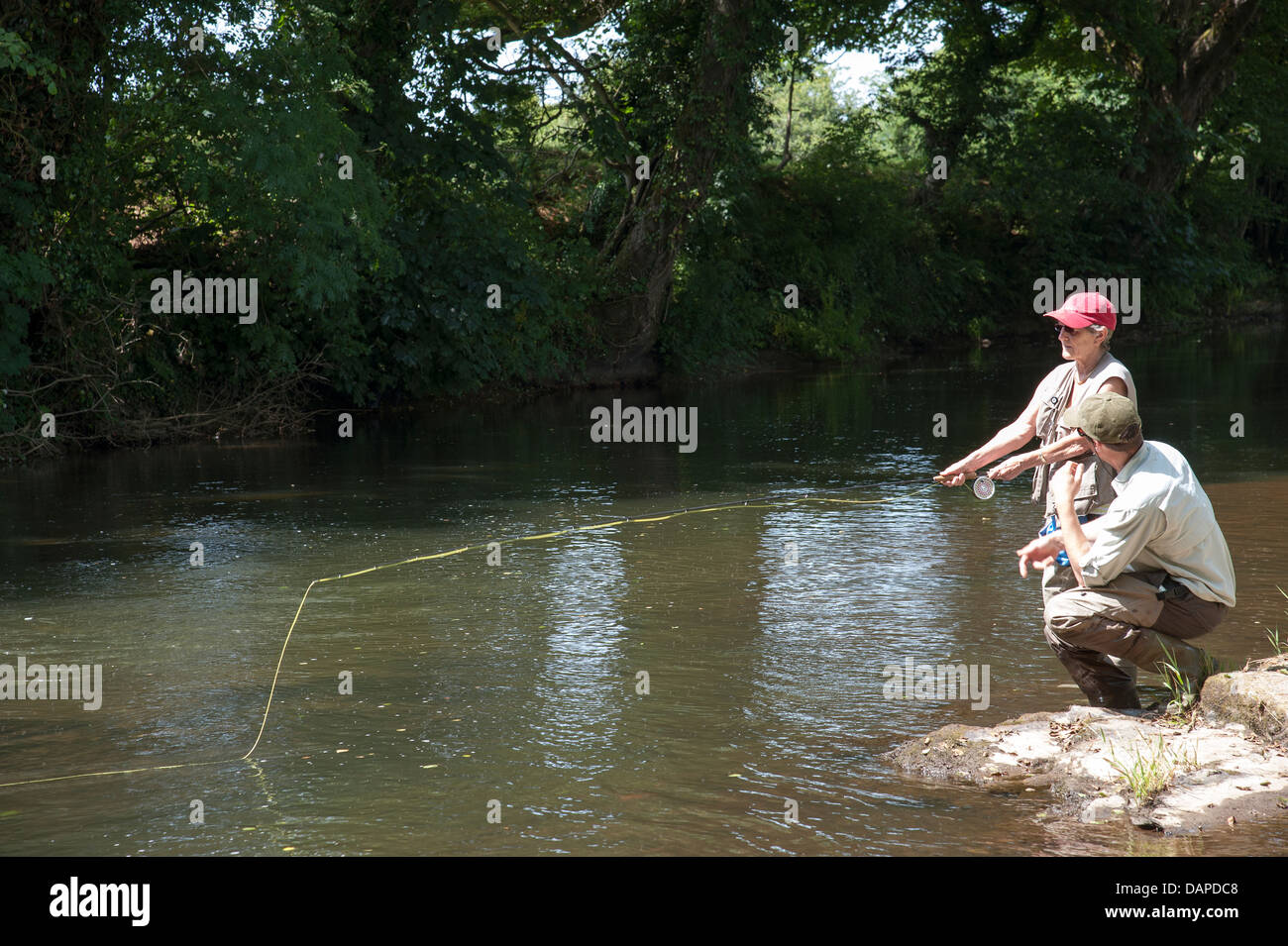 La pesca a mosca un gillie istruire un allievo sul panoramico Fiume Lyd Devon England Regno Unito Foto Stock