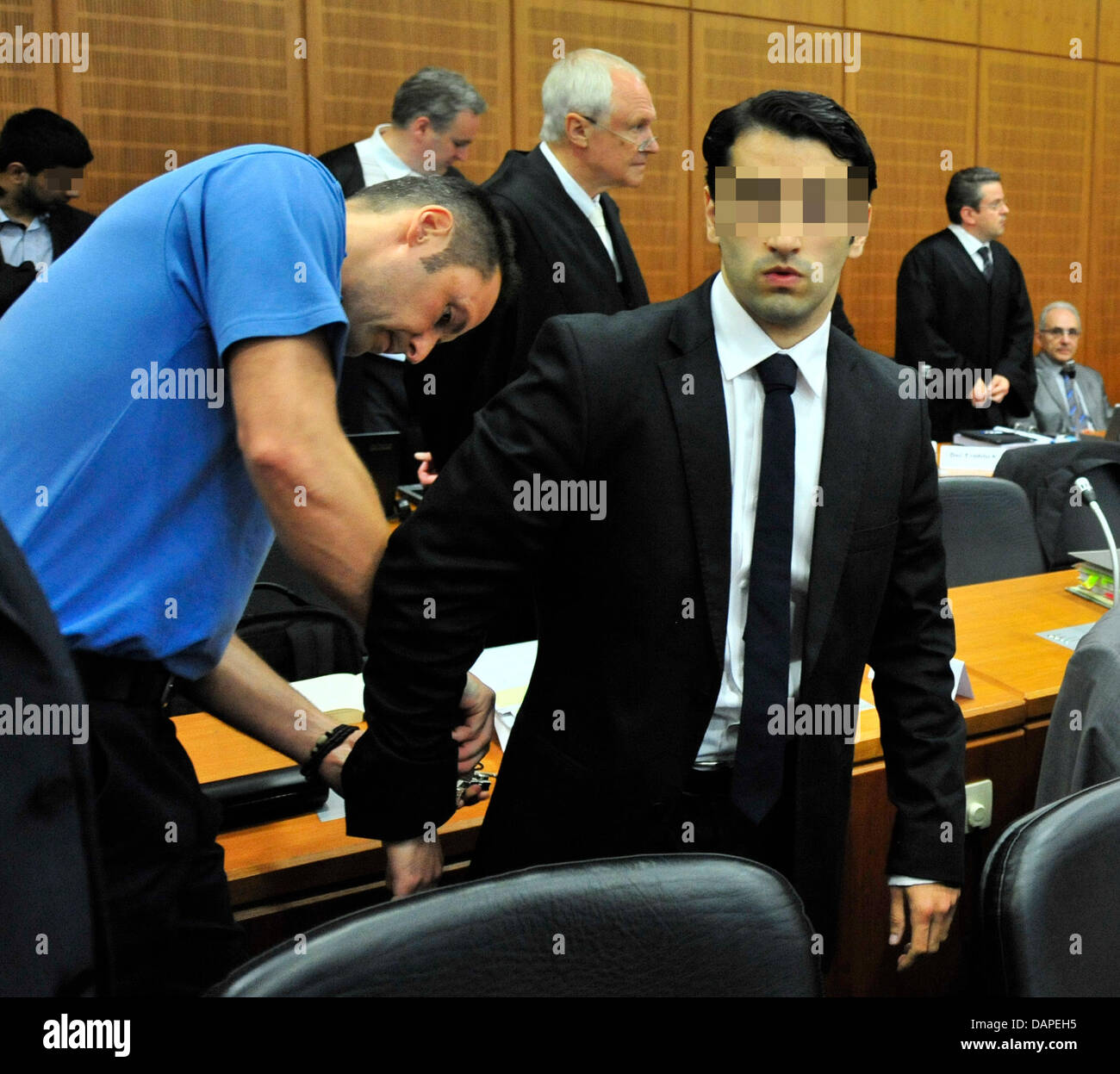 Un funzionario di correzzione rimuove le manette dalla Fraz M. (2 L), accusato di evasione fiscale, prima dell'inizio del processo in un tribunale dell'Alta Corte Regionale di Francoforte sul Meno, Germania, 15 agosto 2011. In totale, sei manager sono in corso dinanzi alla Corte, perché essi sono evasi a pagare 230 milioni di euro di tasse. Secondo le accuse, hanno ingannato il tesoro Foto Stock