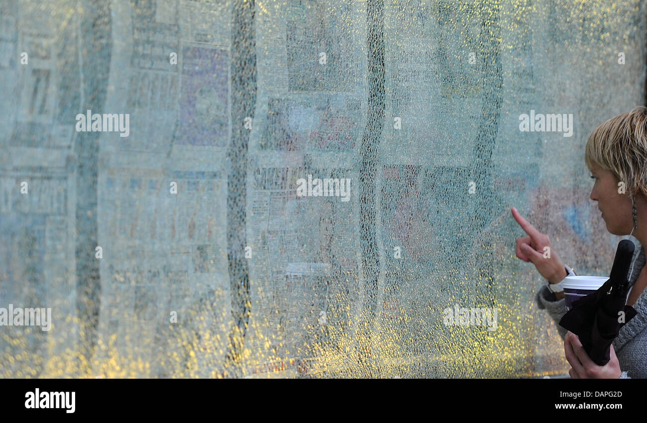 Una faccia di un giornale pagina anteriore è raffigurato dietro il vetro frantumato a Oslo, Norvegia, 19 agosto 2011. Oslo ricorda l'attacco mortale dal 22 luglio in cui 77 persone morirono. Otto di essi sono stati uccisi da un auto bomba nel quartiere governativo di Oslo. Foto: Annibale Foto Stock