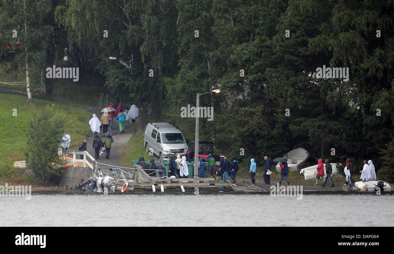 I parenti delle vittime che morirono nella ripresa stand sull isola di Utoya, Norvegia, 19 agosto 2011. Quattro settimane più tardi, Oslo ricorda l'attacco mortale dal 22 luglio in cui 77 persone morirono. Otto di essi sono stati uccisi da un auto bomba nel quartiere governativo di Oslo. Foto: Annibale Foto Stock