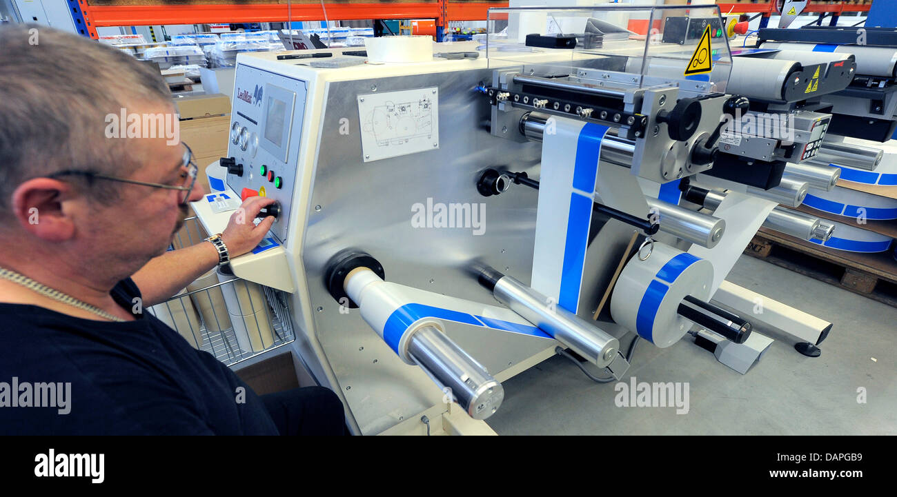 Un ORAFOL Europe dipendente produce la targa adesivi presso la società del  sito di produzione in Oranienburg, Germania, 10 agosto 2011. L'azienda con  602 dipendenti produce self-pellicole adesive ad alta persistenza lamelle