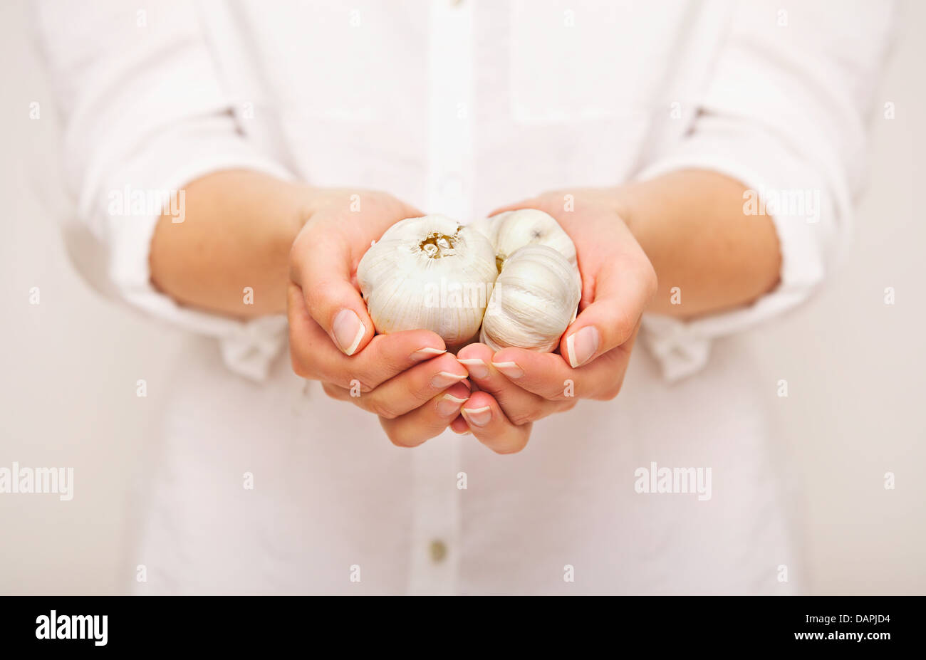 Azienda femmina chiodi di garofano di aglio in entrambe le mani Foto Stock