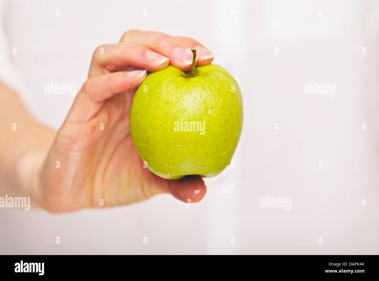 Donna che mantiene una fresca mela verde Foto Stock