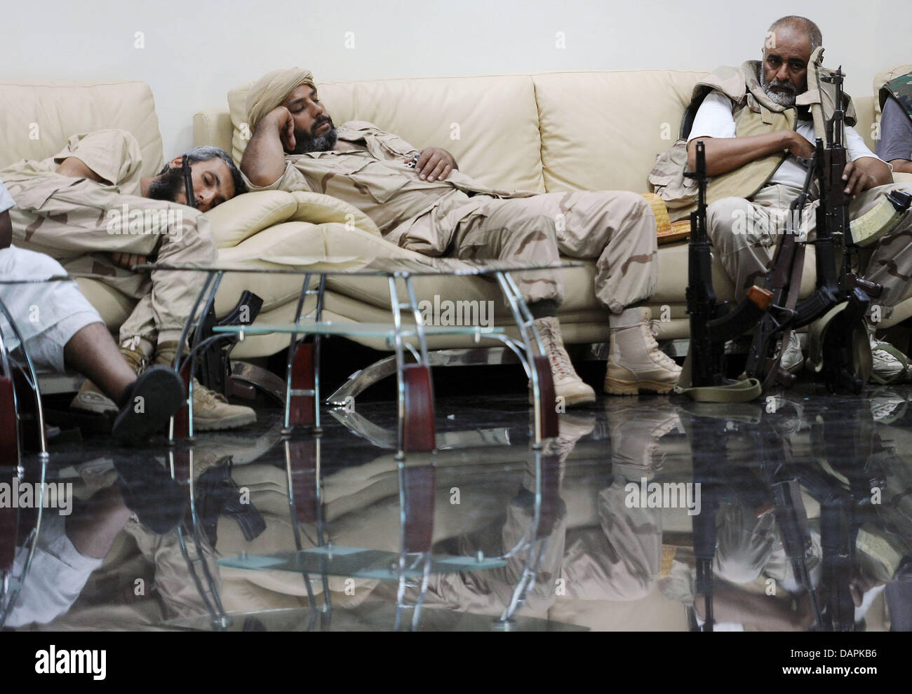 I ribelli armati hanno un pelo giovedì 25 agosto 2011 nell'ex edificio della ministero dell'olio a Tripoli, in Libia. I ribelli si sono scontrati ancora giovedì con i combattenti fedeli a Gheddafi vicino al leader libico di superamento composto nel capitale di Tripoli, un testimone ha detto la stampa tedesca DPA di agenzia. Foto: Annibale +++(c) dpa - Bildfunk+++ Foto Stock