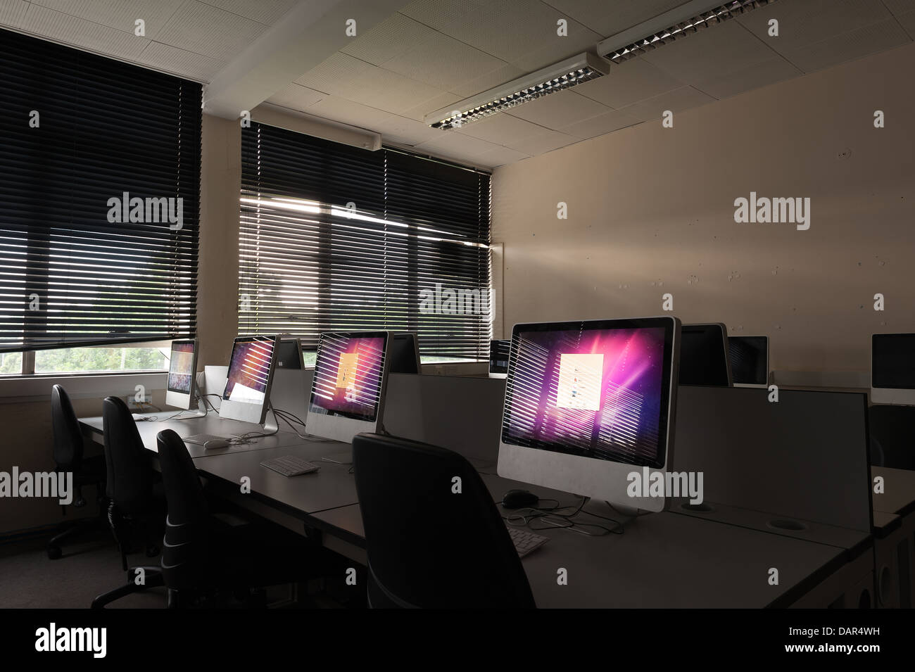 La fine della scuola o college come sappiamo che le righe di computer nel buio di una classe molto precedentemente utilizzato per ora in attesa di essere utilizzati Foto Stock