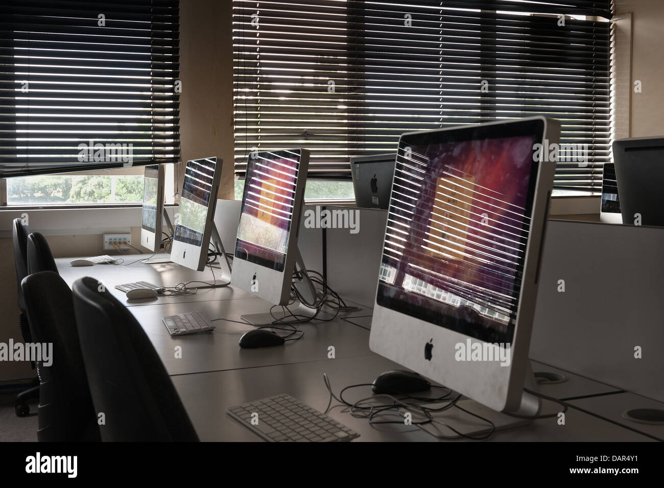 La fine della scuola o college come sappiamo che le righe di computer nel buio di una classe molto precedentemente utilizzato per ora in attesa di essere utilizzati Foto Stock
