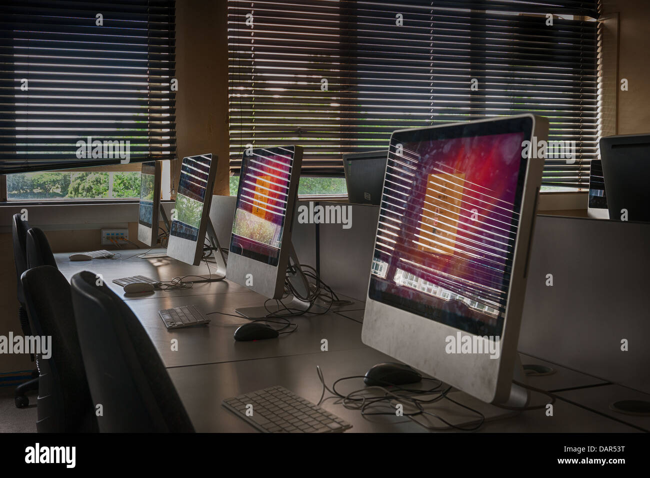 La fine della scuola o college come sappiamo che le righe di computer nel buio di una classe molto precedentemente utilizzato per ora in attesa di essere utilizzati Foto Stock