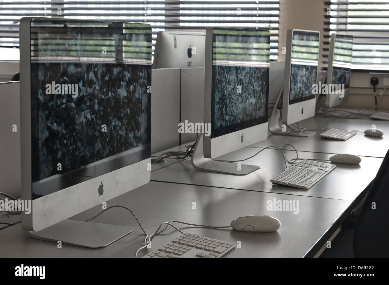 La fine della scuola o college come sappiamo che le righe di computer nel buio di una classe molto precedentemente utilizzato per ora in attesa di essere utilizzati Foto Stock